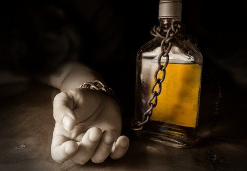 Рука, прикованная к бутылке с алкоголем