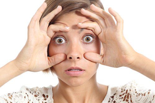 Женщина показывает глаза и недостаток витаминов