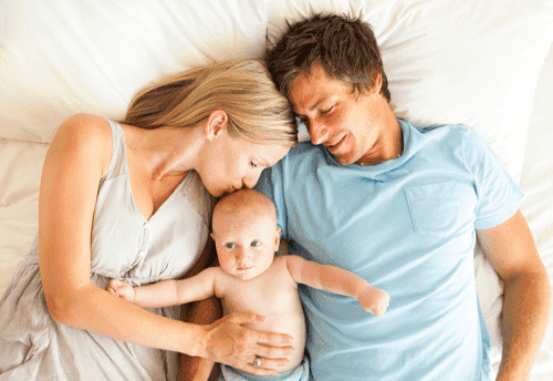 Родители с младенцем в постели