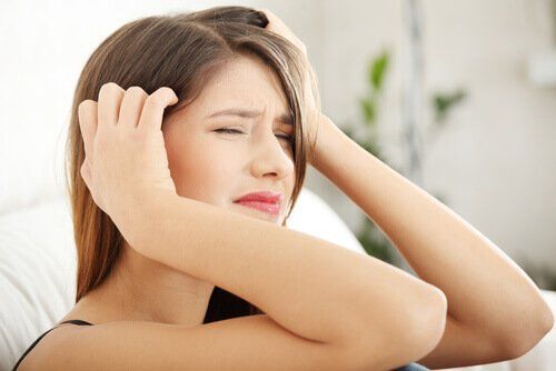 Женщина с сильной головной болью, вызванной стрессом