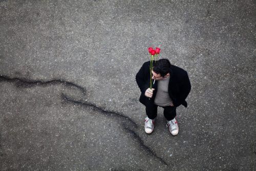 Мужчина ждет на улице с цветами