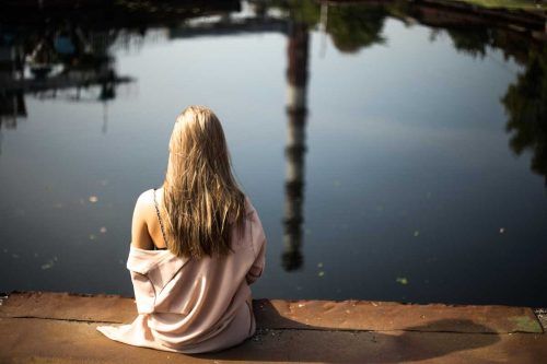 Женщина отдыхает на берегу озера