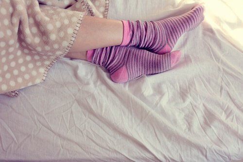 Ноги в носках и теплое одеяло Когда вы не можете спать,