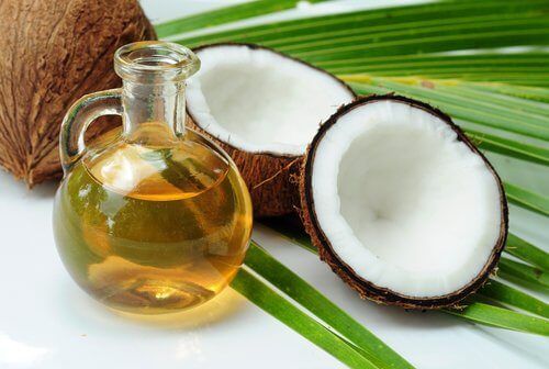 Натуральное кокосовое масло в кувшине и кокосах на пальмовых листьях - более молодой взгляд