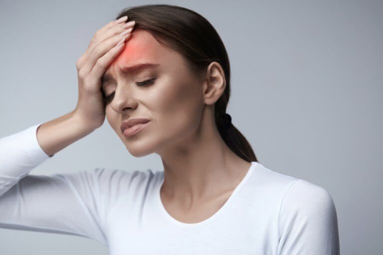 Женщина страдает головной болью и артериальным давлением