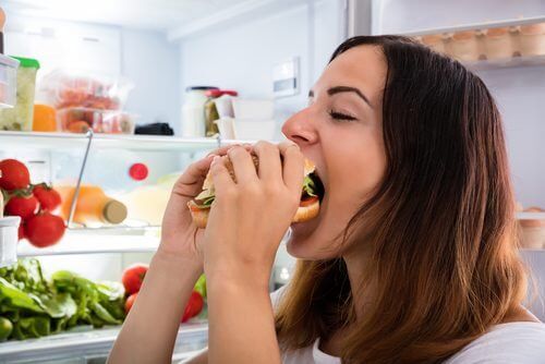 психологический голод - женщина ест гамбургер