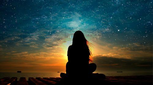 Женщина, медитирующая на закате