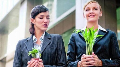 Женщины держат горшки для растений с одним большим вторым меньшим менталитетом жертвы