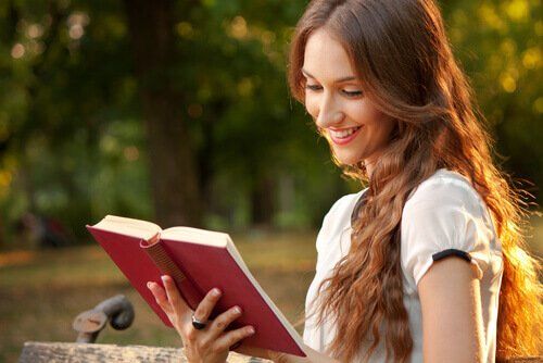 Женщина читает книгу в парке