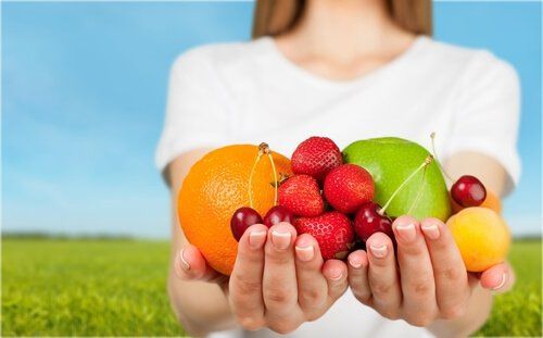 Руки, полные красочных фруктов, богатых питательными веществами