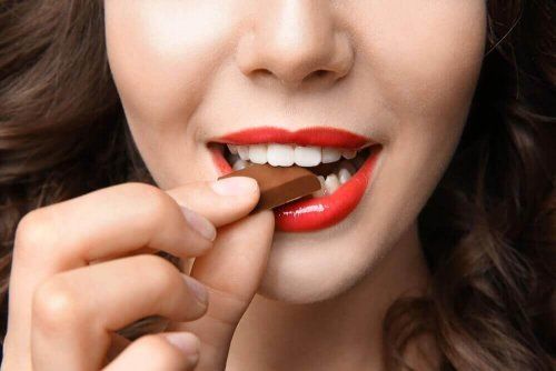 Женщина ест шоколад, пищу, улучшающую настроение