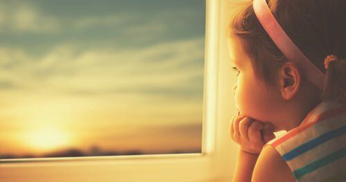 Маленькая девочка смотрит в окно