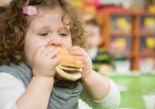 Девушка ест гамбургер