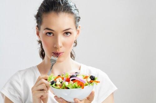 женщина ест салат - хорошие и плохие углеводы