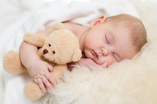 младенец с плюшевым мишкой - пробуждение ребенка для изменения подгузника