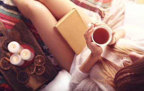 Расслабляющий чай - женщина пьет, читая книгу