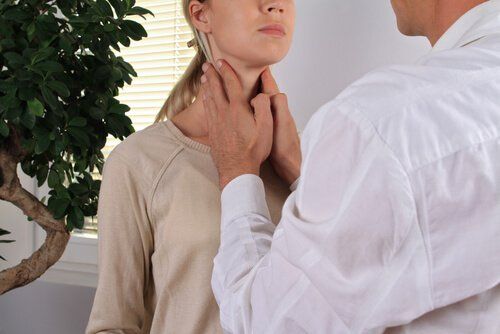 врач, изучающий щитовидную железу у пациента