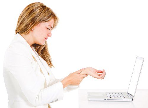 Женщина с болью в запястье после работы на компьютере