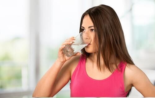 Вода женщина пьет воду, чтобы увлажнять тело и не иметь сухой кожи