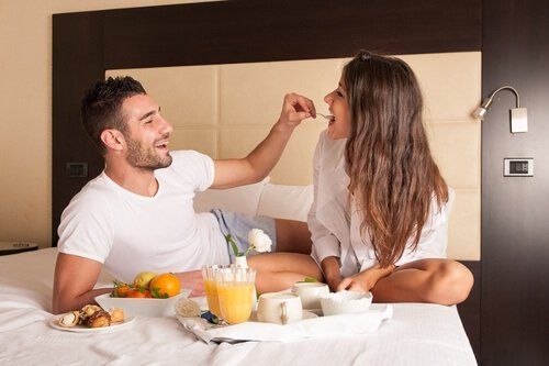 Женщина и мужчины едят в постели