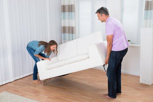 Женщина с мужем перемещает диван, заказывает дома